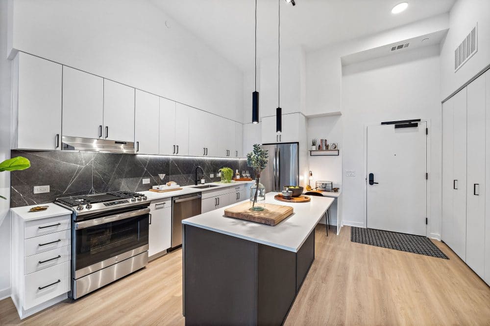 apartment kitchen with white cabinets and royal marble charcoal backsplash tile