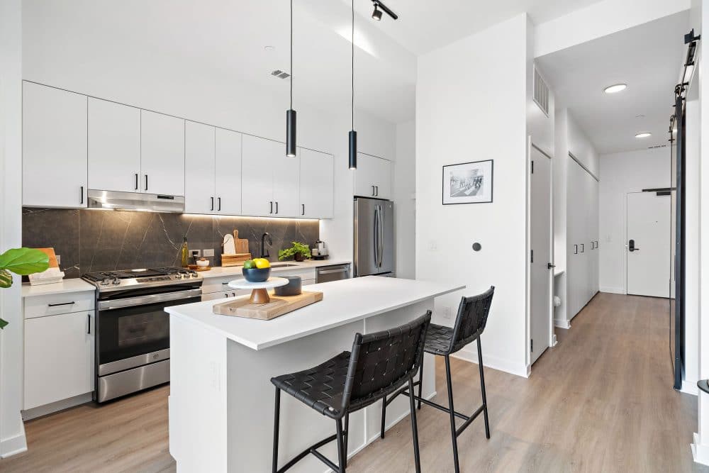 modern kitchen with white countertops and cabinets in a Forth at Navigation apartment home