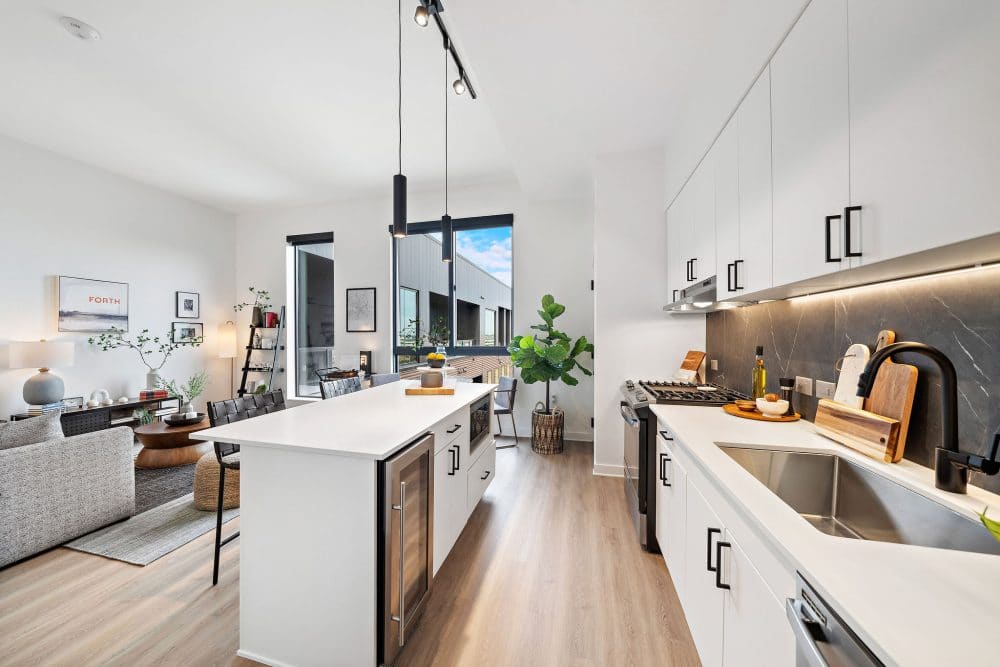 modern kitchen with quartz countertops, stainless steel appliances, and a wine fridge at Forth at Navigation Apartments