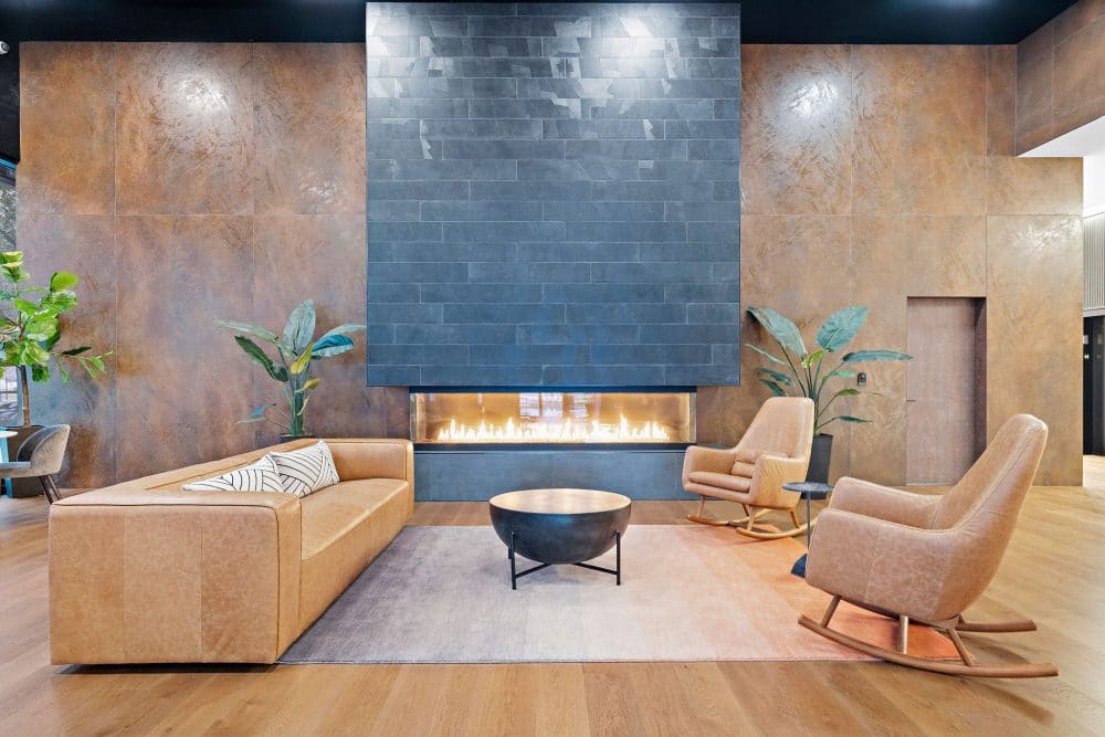 a couch and two rocking chairs in front of a modern fireplace